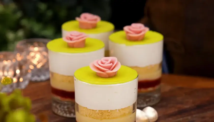 Fyra små prinsesstårta i glas, dekorerade med rosa marsipanrosor och gul marsipanlock. En festlig dessert!