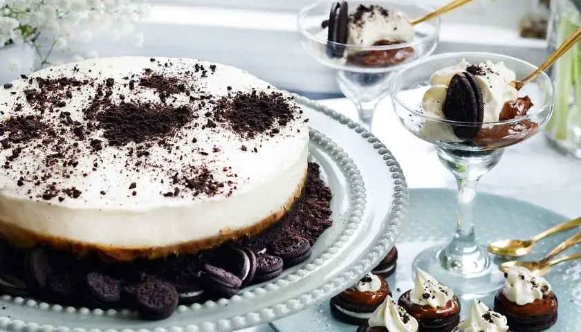 En krämig oreo cheesecake med krossade oreos på toppen. Serveras med små oreo-desserter och i glas.