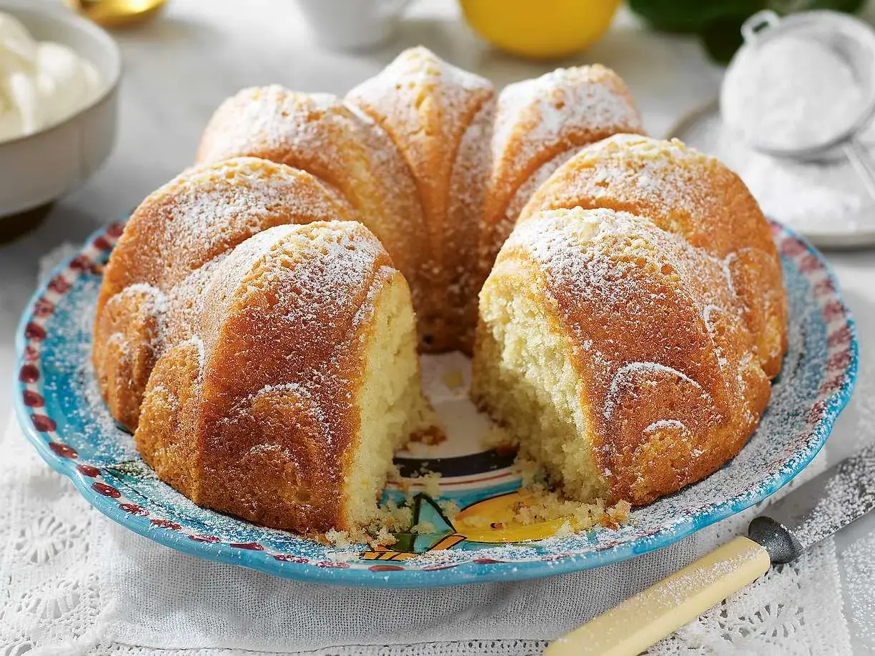 En saftig sockerkaka, perfekt att baka med grekisk yoghurt. Pudrad med florsocker och serverad på en vacker blå tallrik.