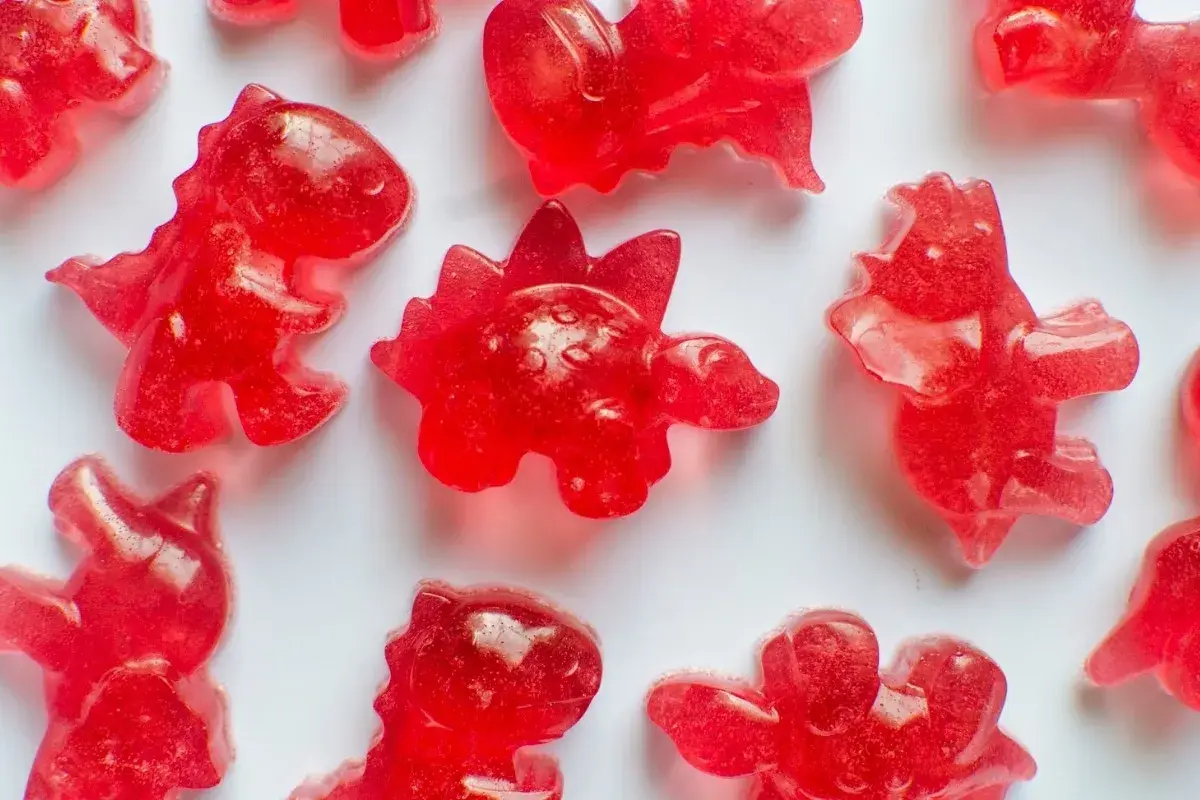 Röda dinosauriegummi, perfekta för ett roligt godis recept. Dessa små dinosaurier är redo att ätas!