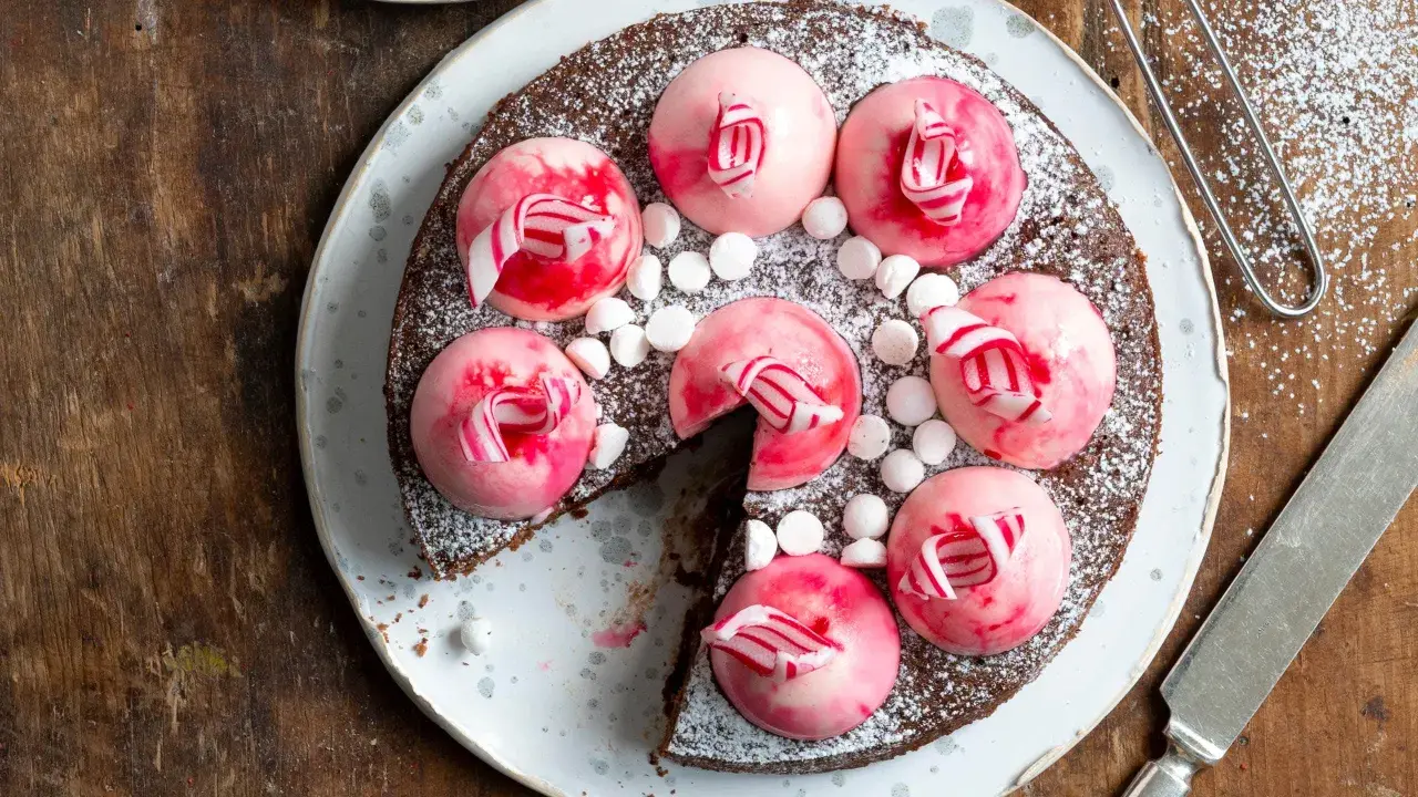 Chokladtårta med rosa polka pannacotta-toppar, strössel av florsocker och små marshmallows.
