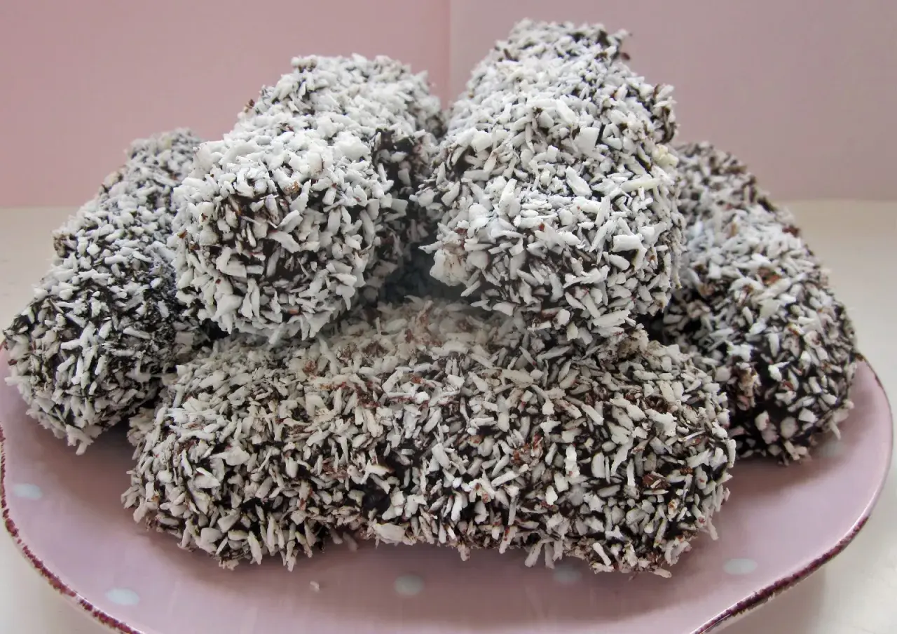 En hög med chokladöverdragna skumbollar, rullade i kokosflingor. Perfekt för ett enkelt skumbollar recept.