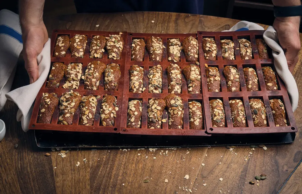 En form med nybakade, saftiga kavringsmuffins toppade med frön och havre. Perfekt för fikat!