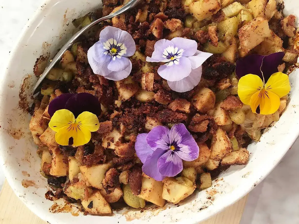 En härlig ansa rabarberpaj med krispigt täcke, dekorerad med vackra penséer.