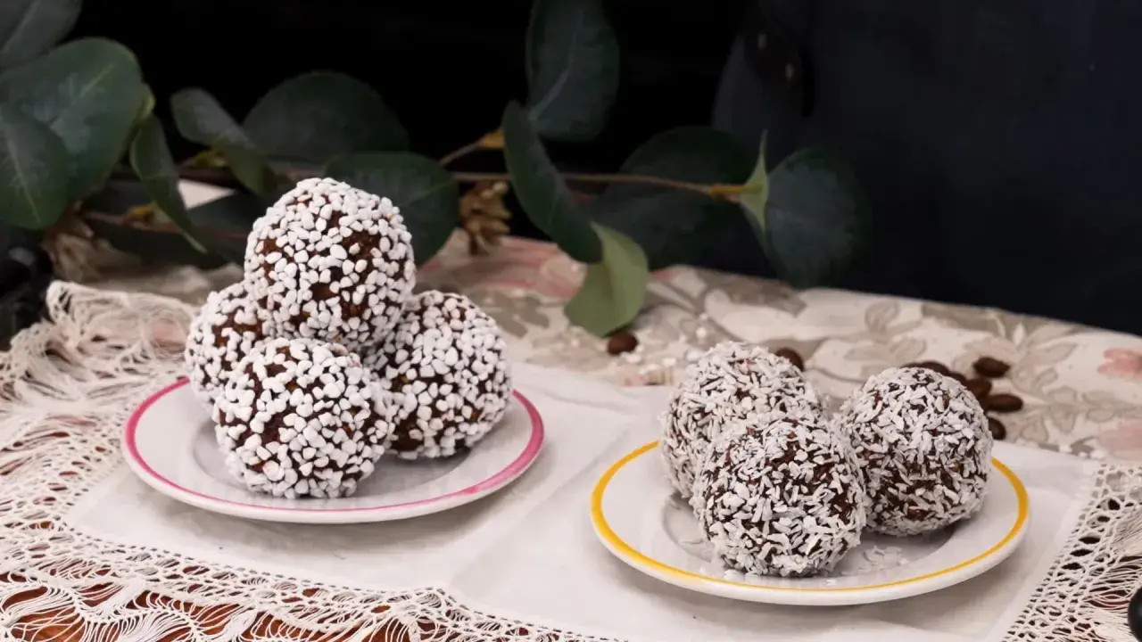 Två fat med chokladbollar, några rullade i kokosflingor och andra i små vita strösselkulor. En härlig syn av kokos bollar!