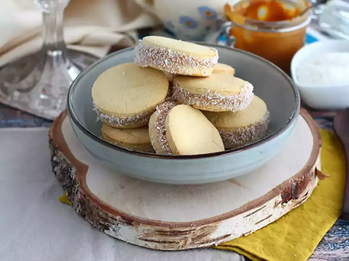 En skål med alfajores, perfekta för överblivna äggulor recept. Dessa småkakor är fyllda med dulce de leche och rullade i kokosflingor.
