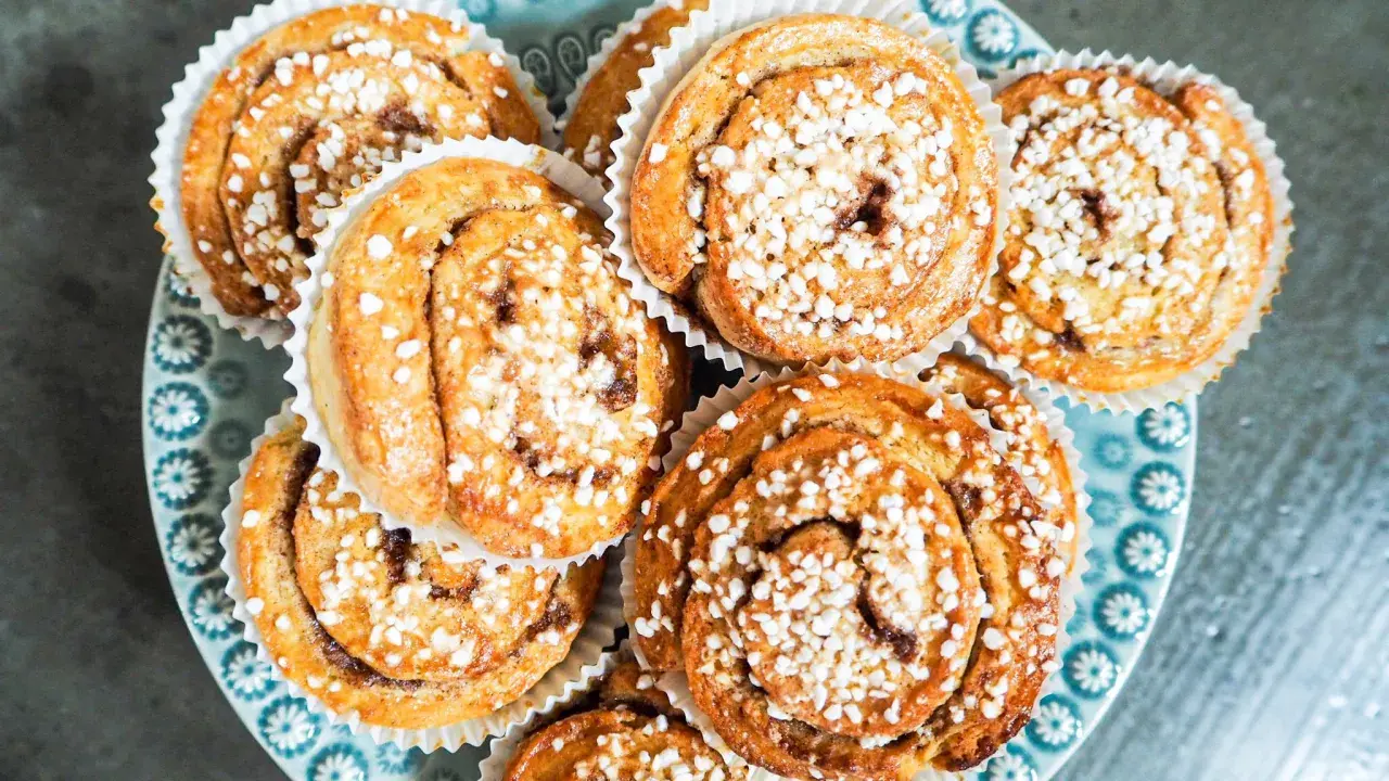 En tallrik med gyllene, snabba bullar toppade med pärlsocker. Perfekt för fikat!