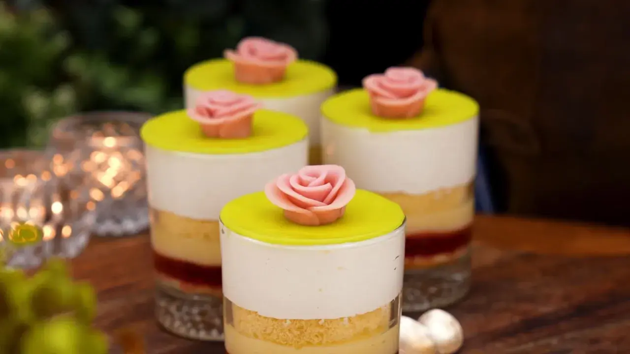 Fyra små prinsesstårta i glas, dekorerade med rosa marsipanrosor och gul marsipanlock. En festlig dessert!