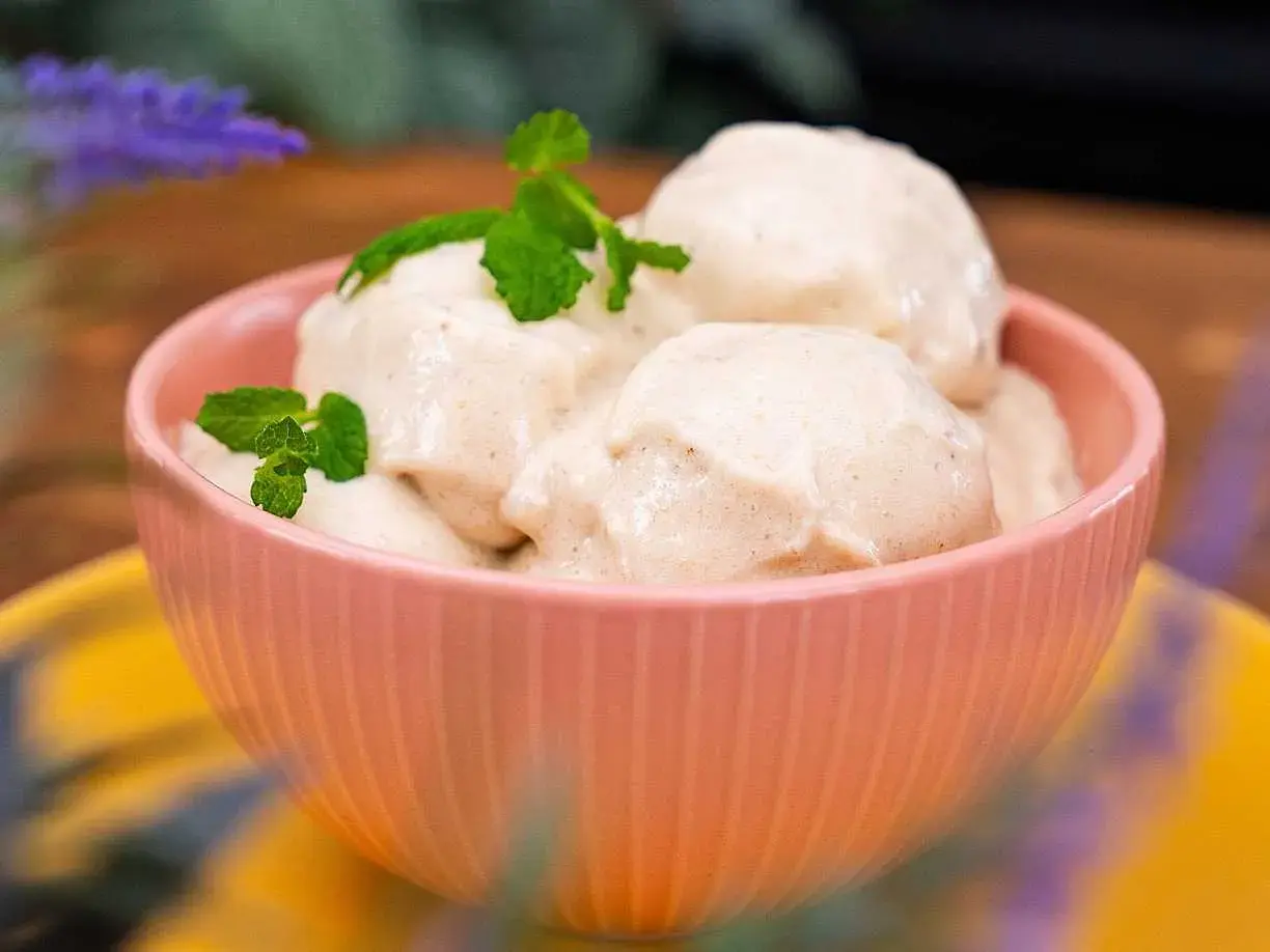 En skål med krämig nice cream, toppad med mynta. Perfekt för en varm sommardag.