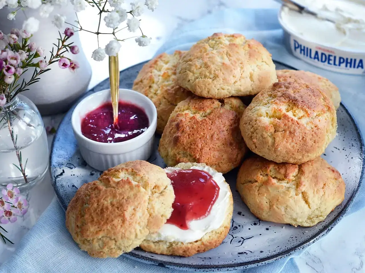En h&ouml;g med klassiska scones, en sk&aring;l med sylt och en burk f&auml;rskost. En perfekt fika!