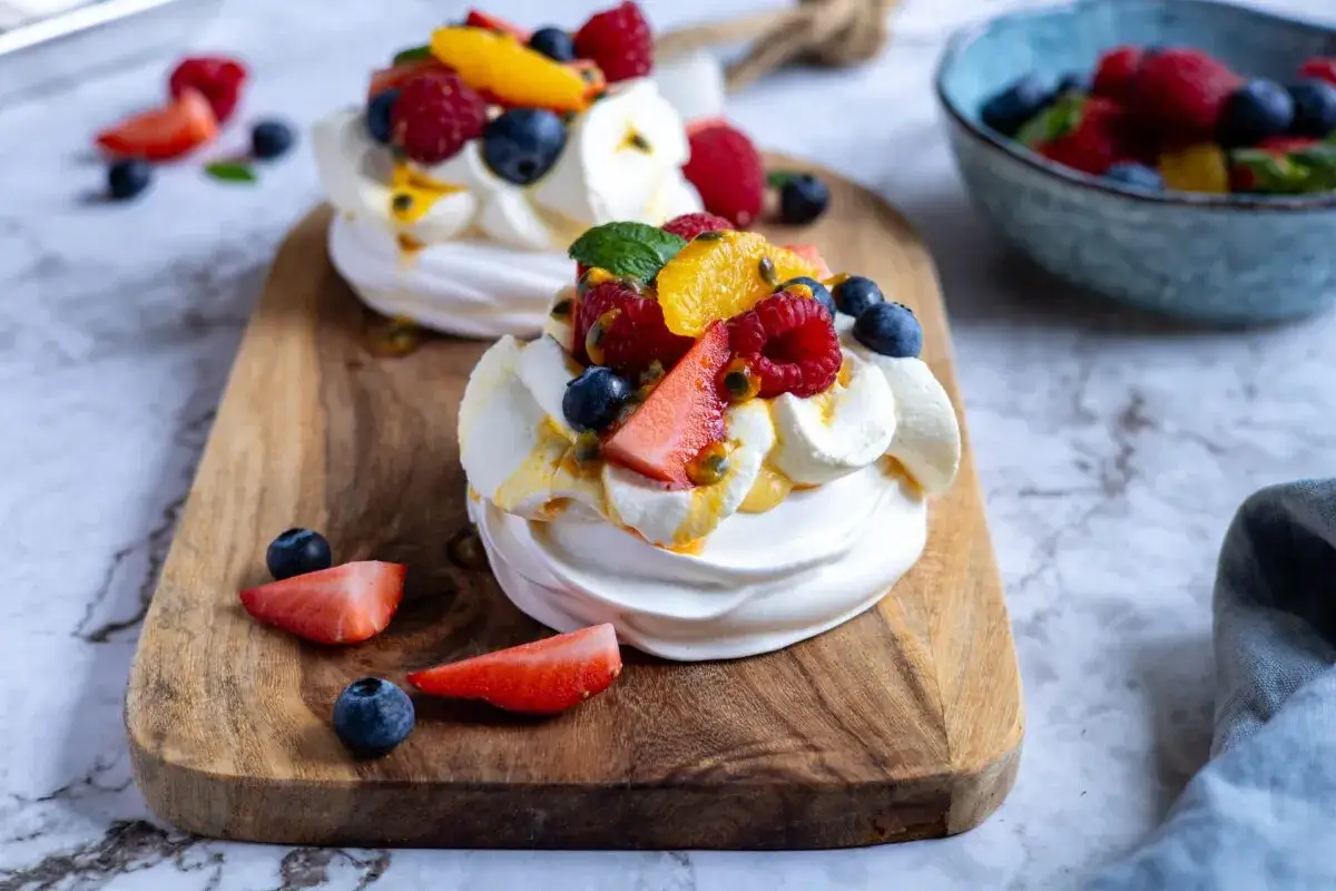 Tv&aring; l&auml;ckra pavlovakakor med gr&auml;dde och f&auml;rska b&auml;r, perfekt f&ouml;r ett somrigt pavlova recept.