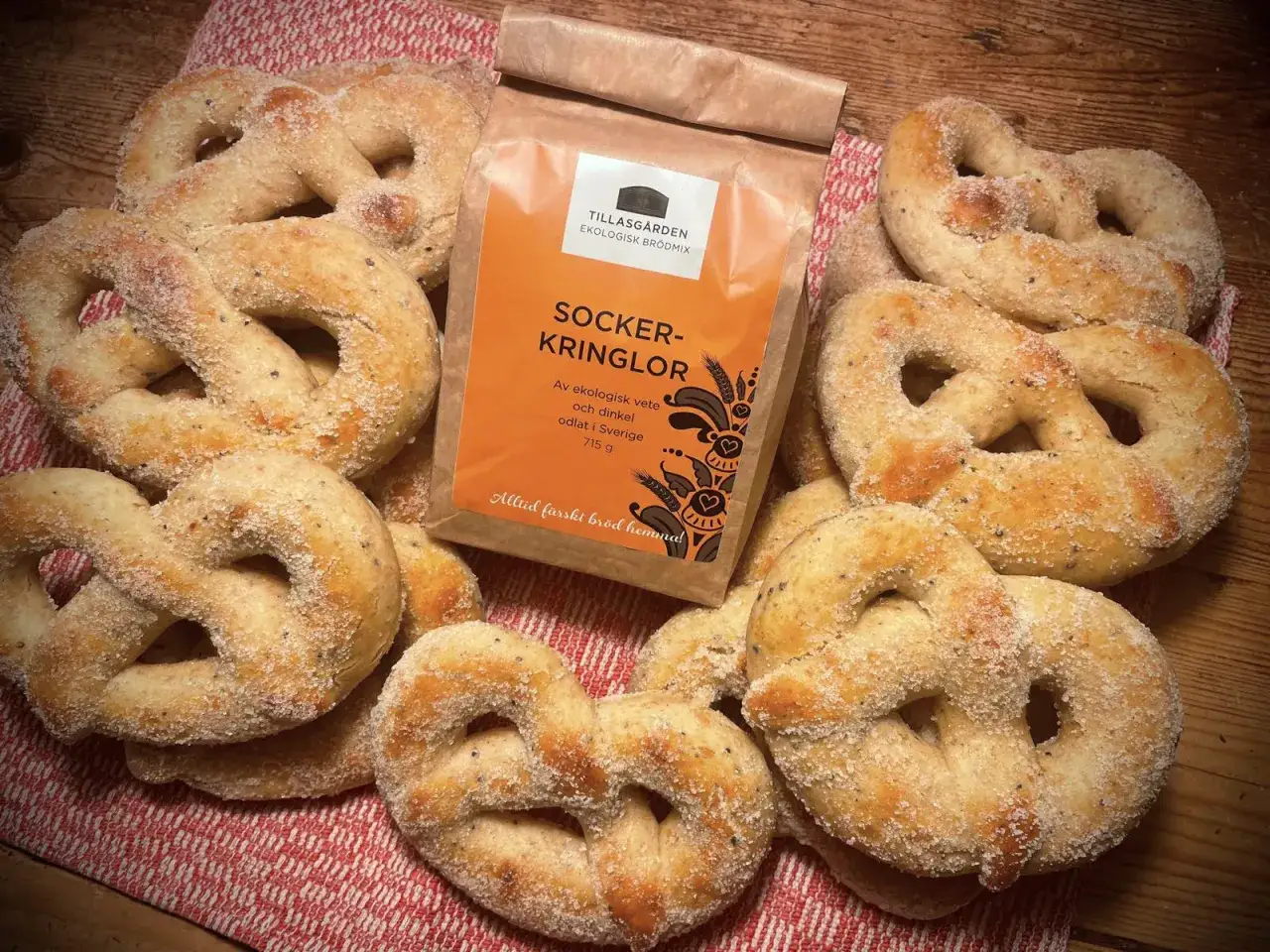 Nybakade socker kringlor, redo att avnjutas. En p&aring;se ekologisk br&ouml;dmix fr&aring;n Tillasg&aring;rden ligger bredvid, perfekt f&ouml;r att baka med l&auml;tta ingredienser.