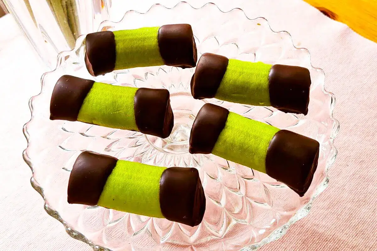 Fem gr&ouml;na dammsugare med chokladtoppar ligger p&aring; ett glasfat. En h&auml;rlig dammsugare kaka!