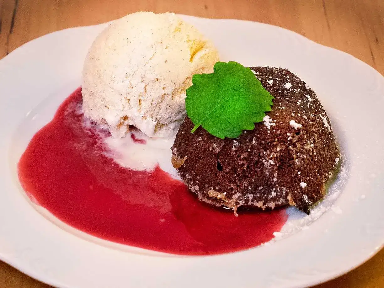 En l&auml;cker choklad fondant med vaniljglass, hallons&aring;s och en myntakvist.