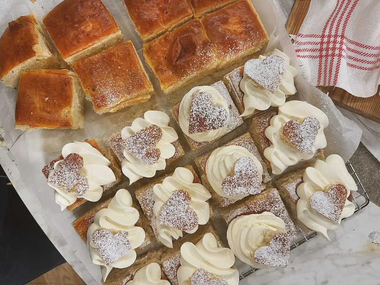 Gammaldags semlor i fyrkantig form, toppade med fluffig gr&auml;dde och hj&auml;rtformade kakor, pudrade med florsocker.