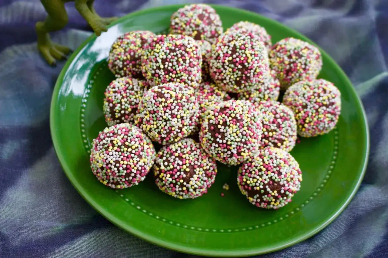 Chokladbollar recept barn: Mumsiga chokladbollar med f&auml;rgglatt str&ouml;ssel p&aring; en gr&ouml;n tallrik. Perfekt f&ouml;r sm&aring; h&auml;nder!